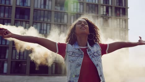 mujer joven de moda en el techo urbano usando una granada de humo