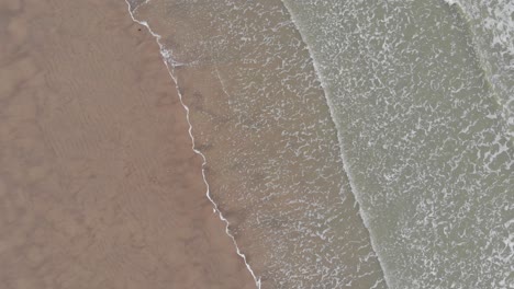 the beach and the sea seen from above with a turning drone