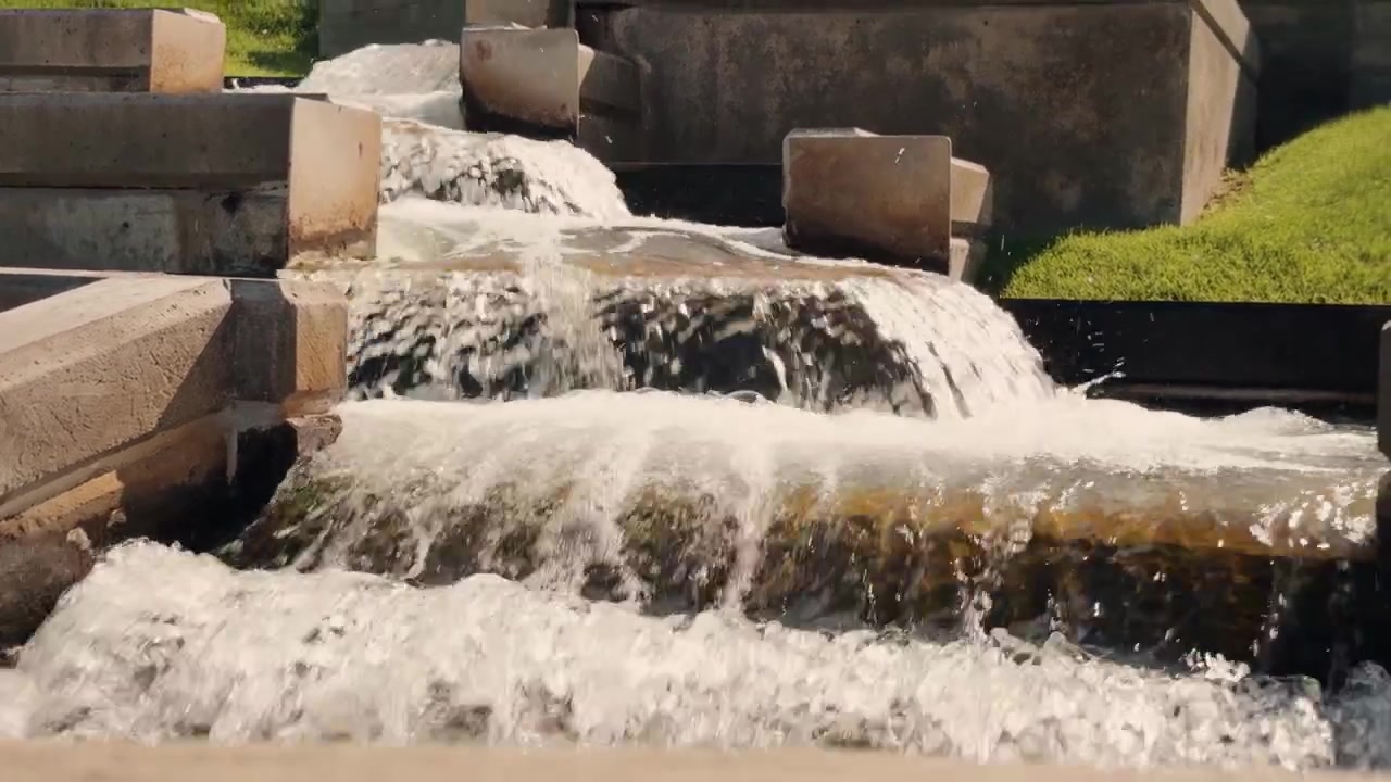 Downward glide follows tiered fountain flow and ends behind a low wall.