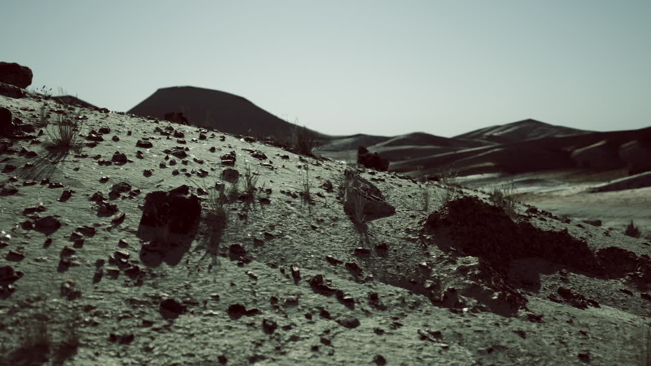 Vast mongolian landscape with rolling hills and rocky terrain under a clear sky