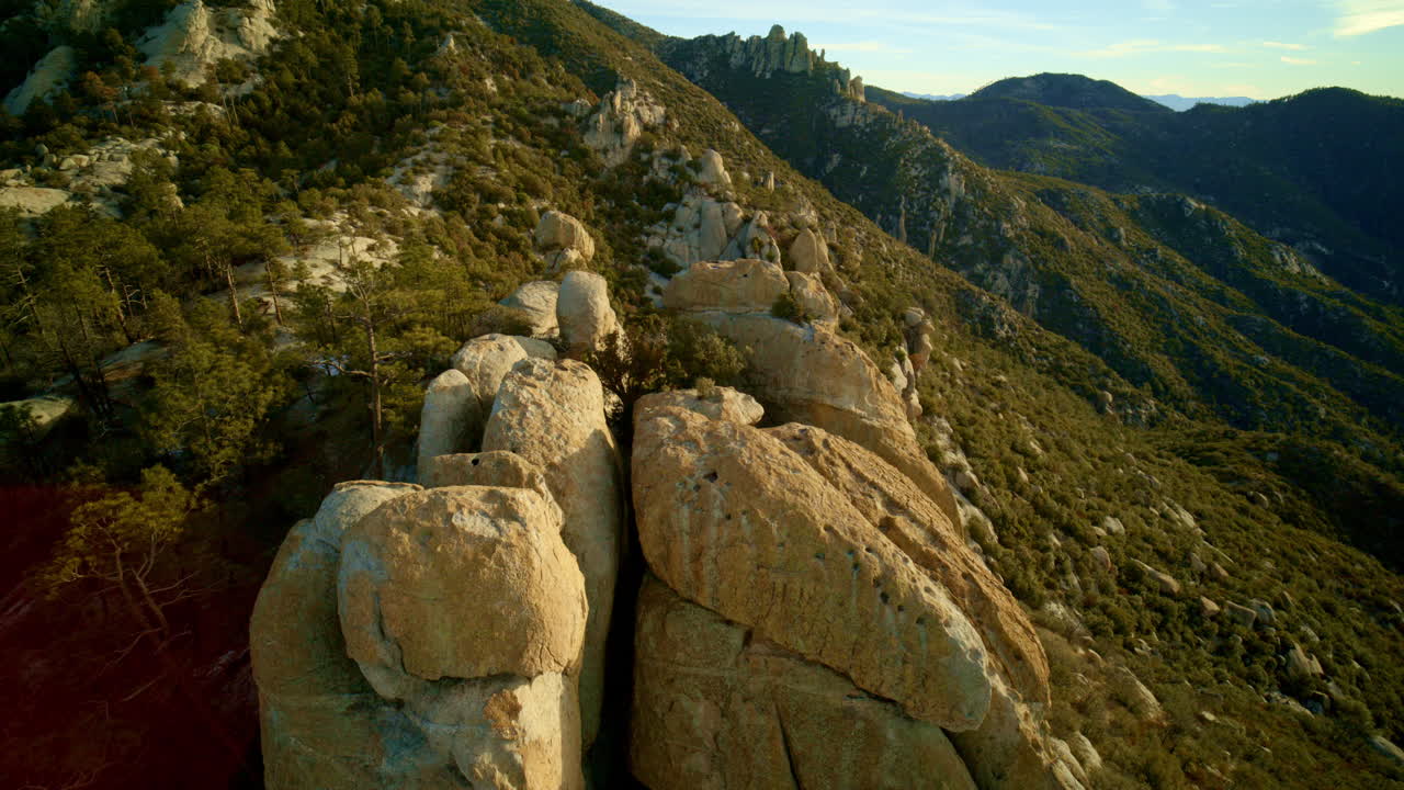 드론이 사막 산의 에 있는 후두 바위 형성 위를 날아다니고 있습니다.