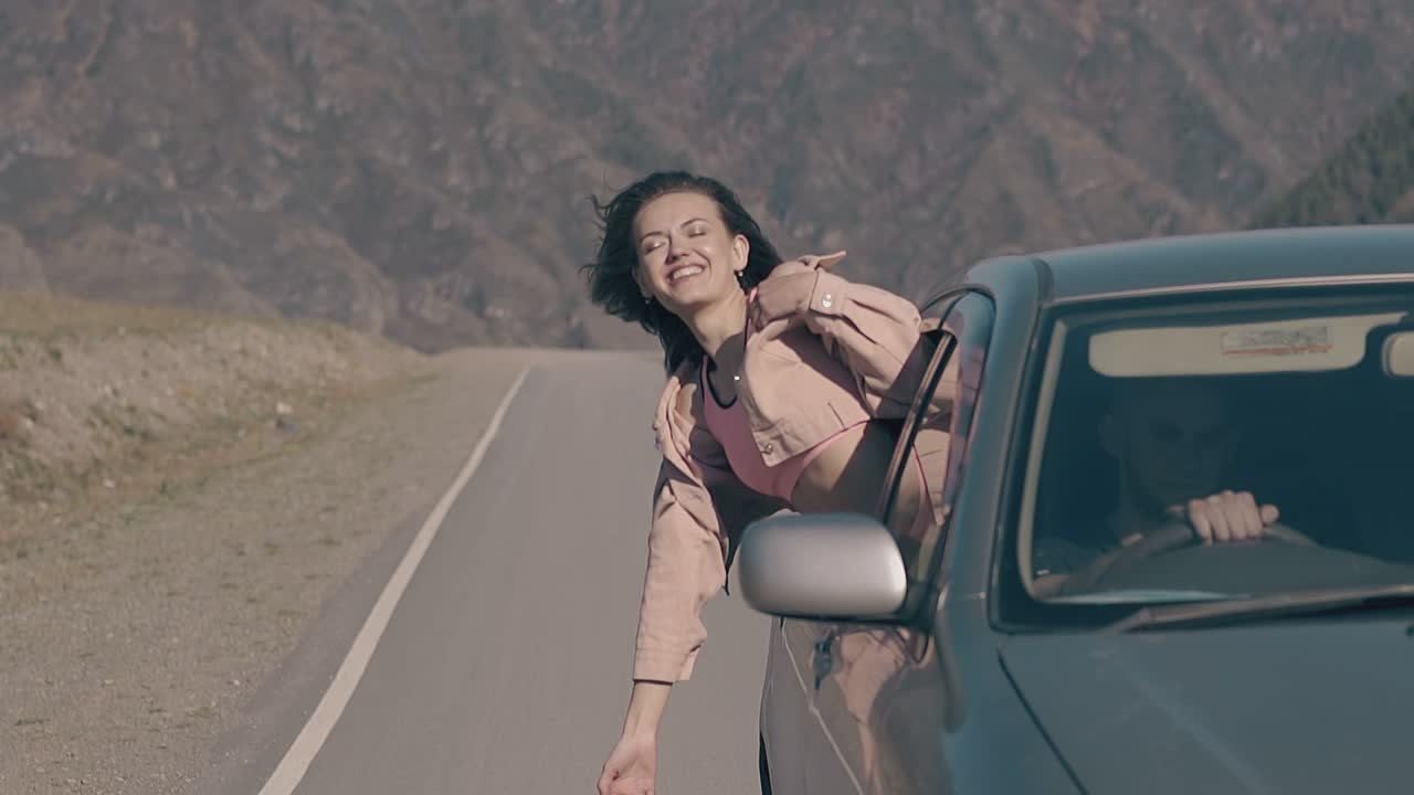 la morena parece salir de conducir el coche y sonríe disfrutando de la vida