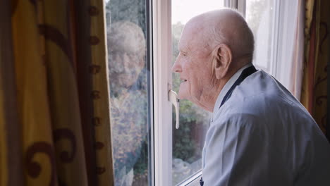 elderly man looking out the window