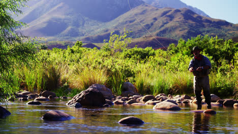 man fly fishing in river