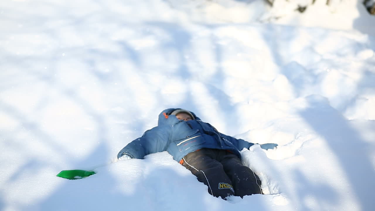 Boy playing with snow. Little boy playing and spending time with snow