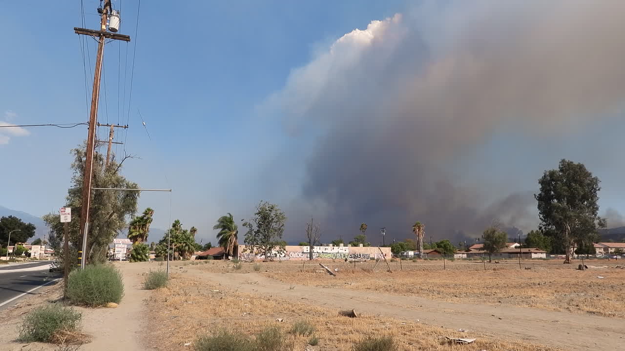 nubes ondulantes fuman de un incendio forestal de bosques en llamas detrás de las estructuras