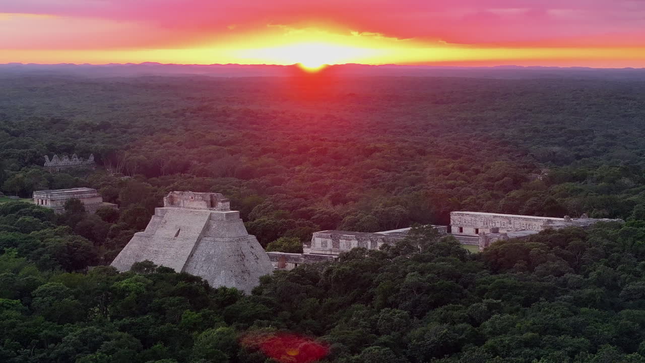 Aerial establishing orbit of the ancient Mayan city of Uxmal during a vibrant sunset in Yucatan, Mexico