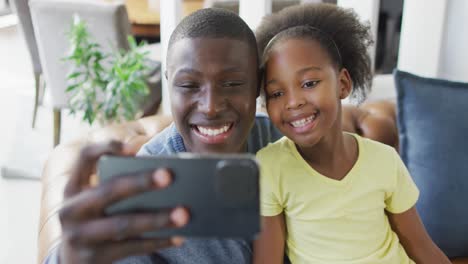 Video-Eines-Afroamerikanischen-Vaters-Und-Seiner-Tochter,-Die-Ihr-Smartphone-Benutzen