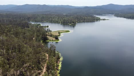 Drone-Volando-Sobre-Un-Hermoso-Lago-Hacia-Una-Península-Verde