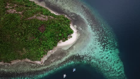 a top-down rotating aerial view of an island in the philippines, featuring pristine, crystal-clear waters