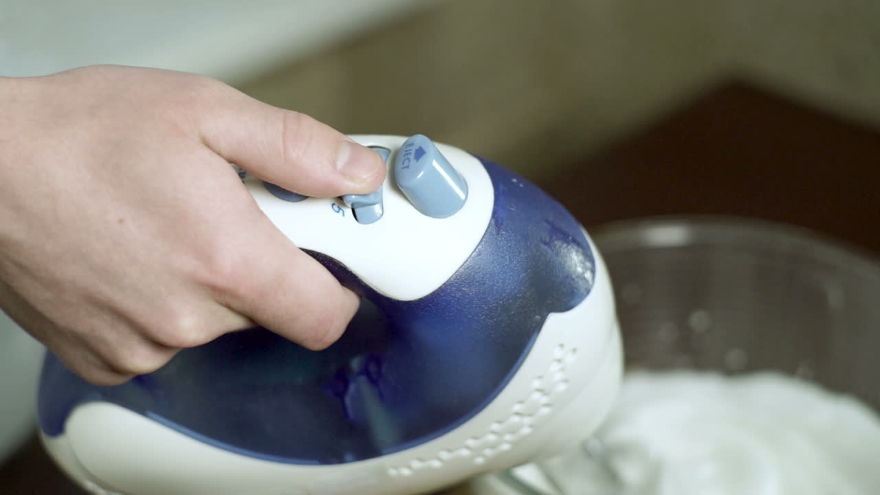 손으로 전기 믹서의 속도를 전환합니다. 주방 용품