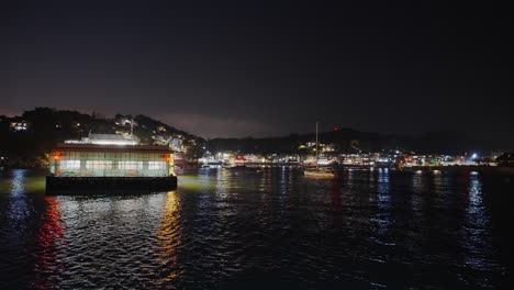 toma nocturna de una pequeña zona de atraque, puerto, en una pequeña isla al lado de un pequeño pueblo