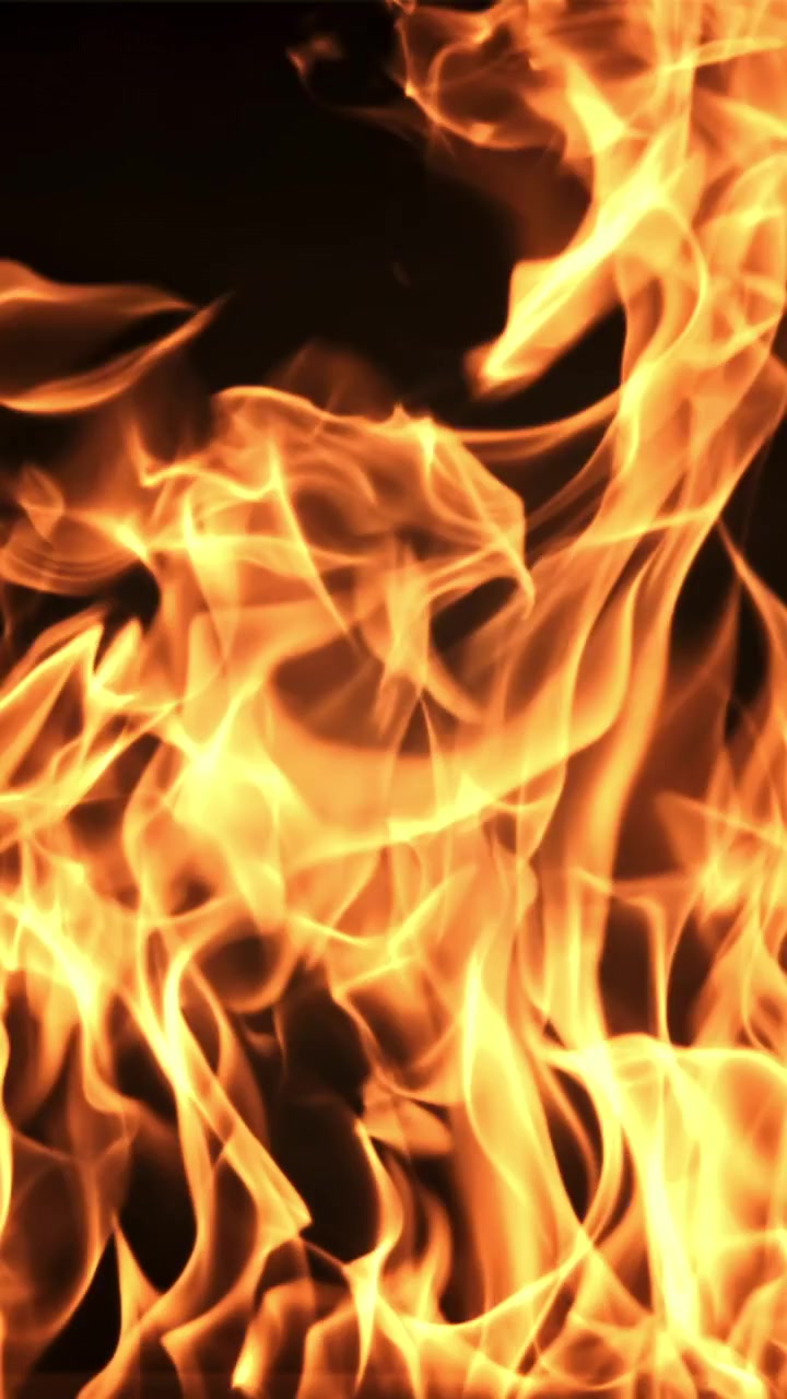 Primo piano di fiamme arancioni e gialle brillanti su sfondo nero
