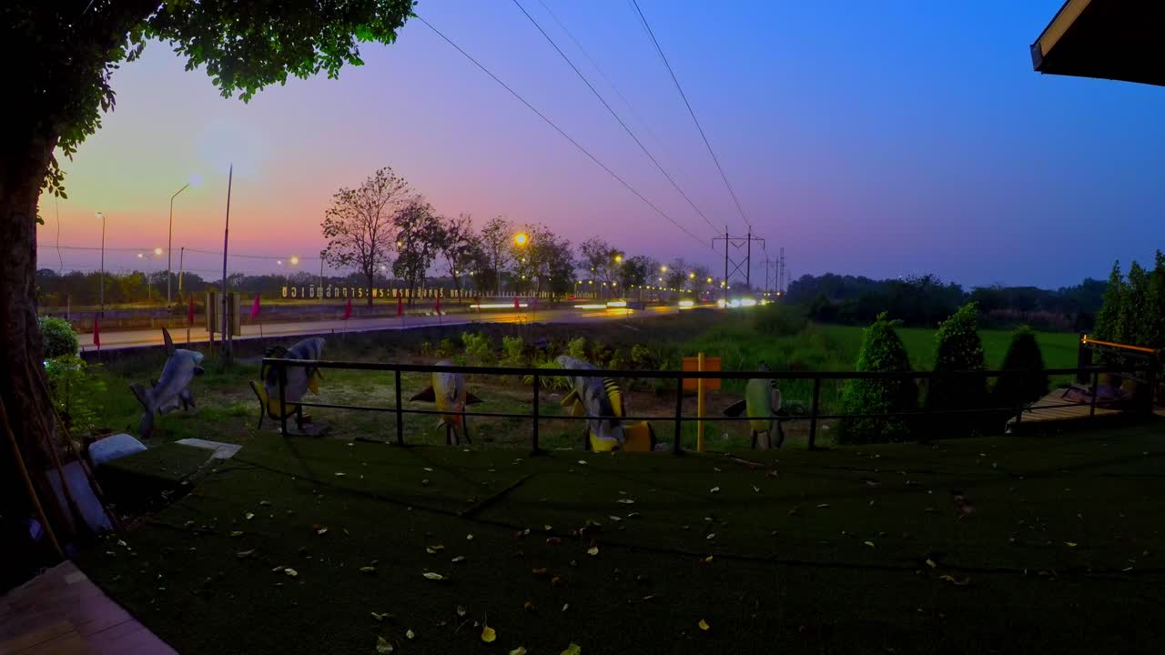 Day to night transition of highway traffic timelaps near to green paddy field