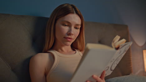 dreamy woman reading bed at apartment close up. calm girl enjoy romantic novel