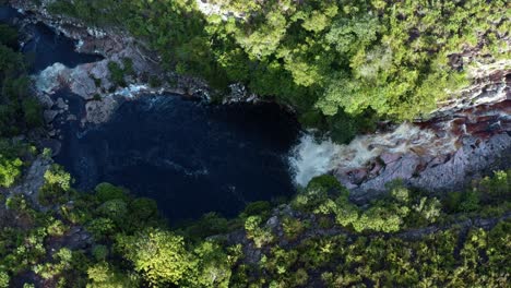 Luftdrohne-Weite-Vogelperspektive-Aufsteigender-Schuss-Des-Atemberaubenden-Devil&#39;s-Pit-Wasserfalls,-Umgeben-Von-Felsen-Und-Dschungellaub-Im-Wunderschönen-Chapada-Diamantina-Nationalpark-Im-Nordosten-Brasiliens