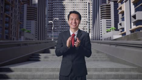un hombre de negocios asiático aplaudiendo impresionantemente en la ciudad