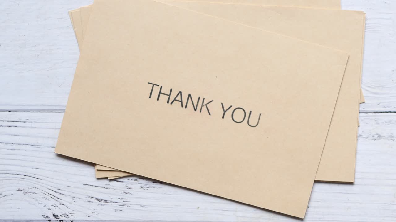 Mensagem de agradecimento e envelope na mesa de madeira