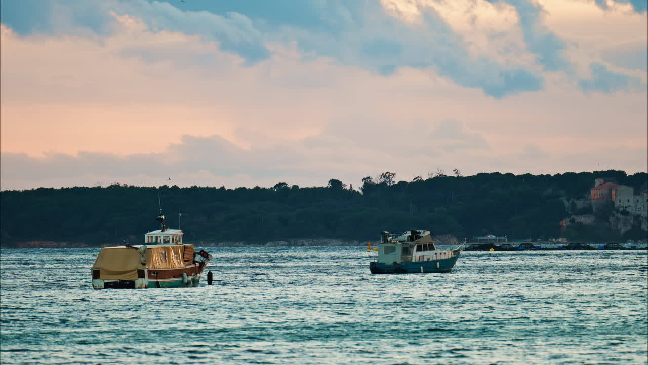 Boats floating on the sea in Juan-les-Pins, France at sunset