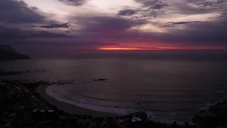 increíble disparo de drone sobre la bahía de los campamentos durante el atardecer de colores púrpura y naranja