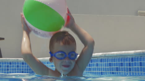 little playful child with ball in pool