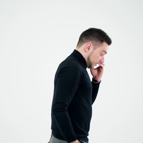 handsome man having phone talk indoors. serious young businessman talking on a cellphone and moves slowly isolated on white background. slow motion.