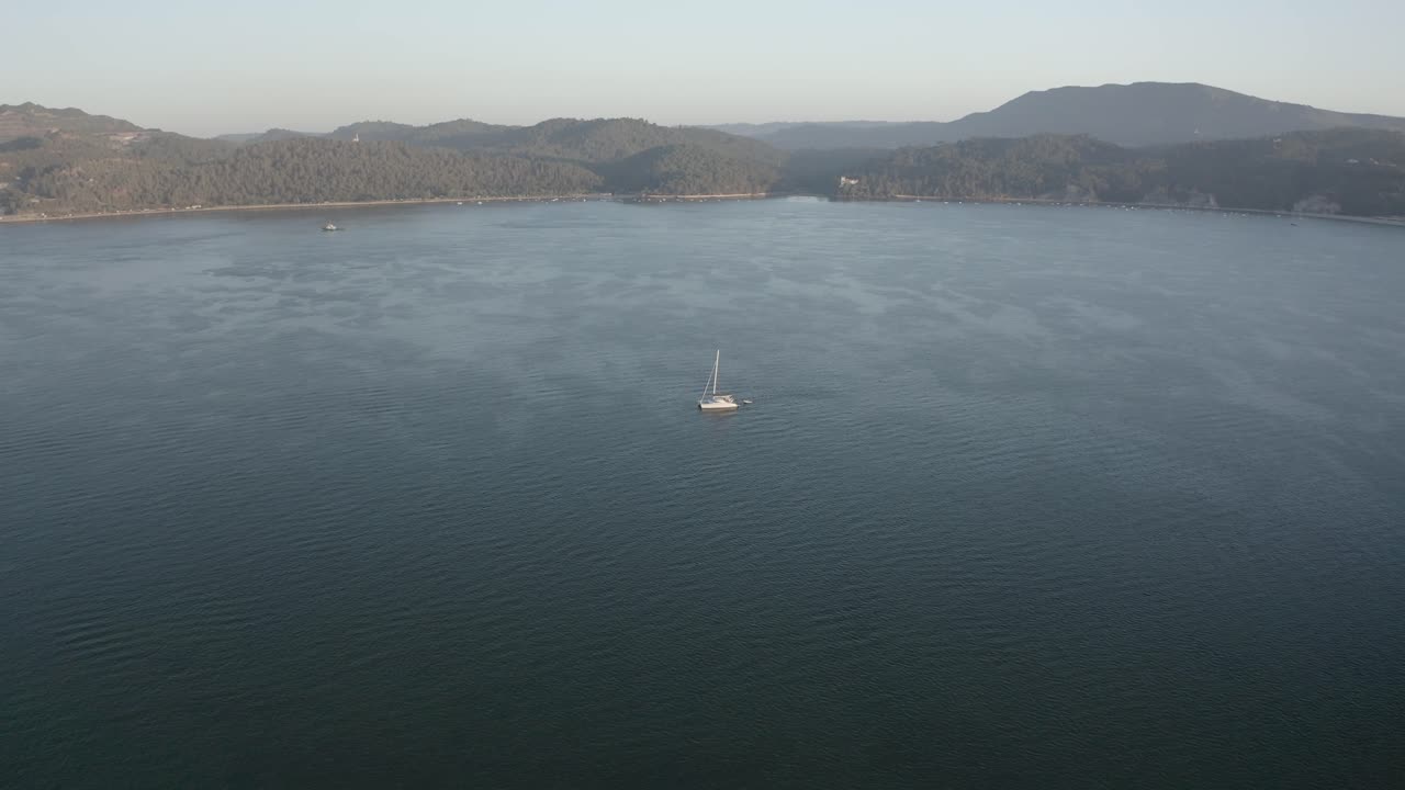 imágenes aéreas de drones de un catamarán en el océano en hora dorada con un clima nublado en el fondo 4k