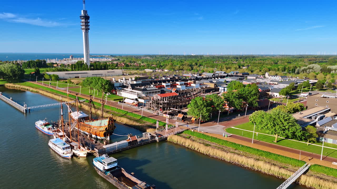 Berth with the ships at the lakefront of Lelystad, the Netherlands. Aerial perspective on museum Batavialand and telecom tower.