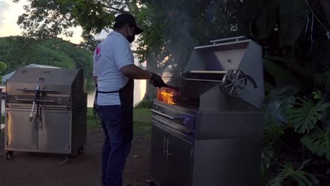 parrilla mexicana latina taquero parrilla barbacoa con llamas en la rejilla preparando carne de filete cruda en el lago del jardín servicio de fiesta al atardecer