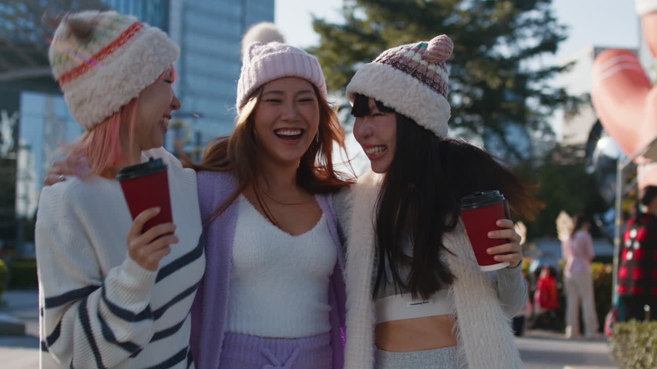 Three women enjoying coffee outdoors in winter