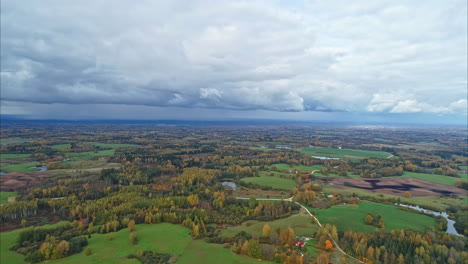 volando sobre un campo verde de bosques de colores de otoño y campos verdes de hierba