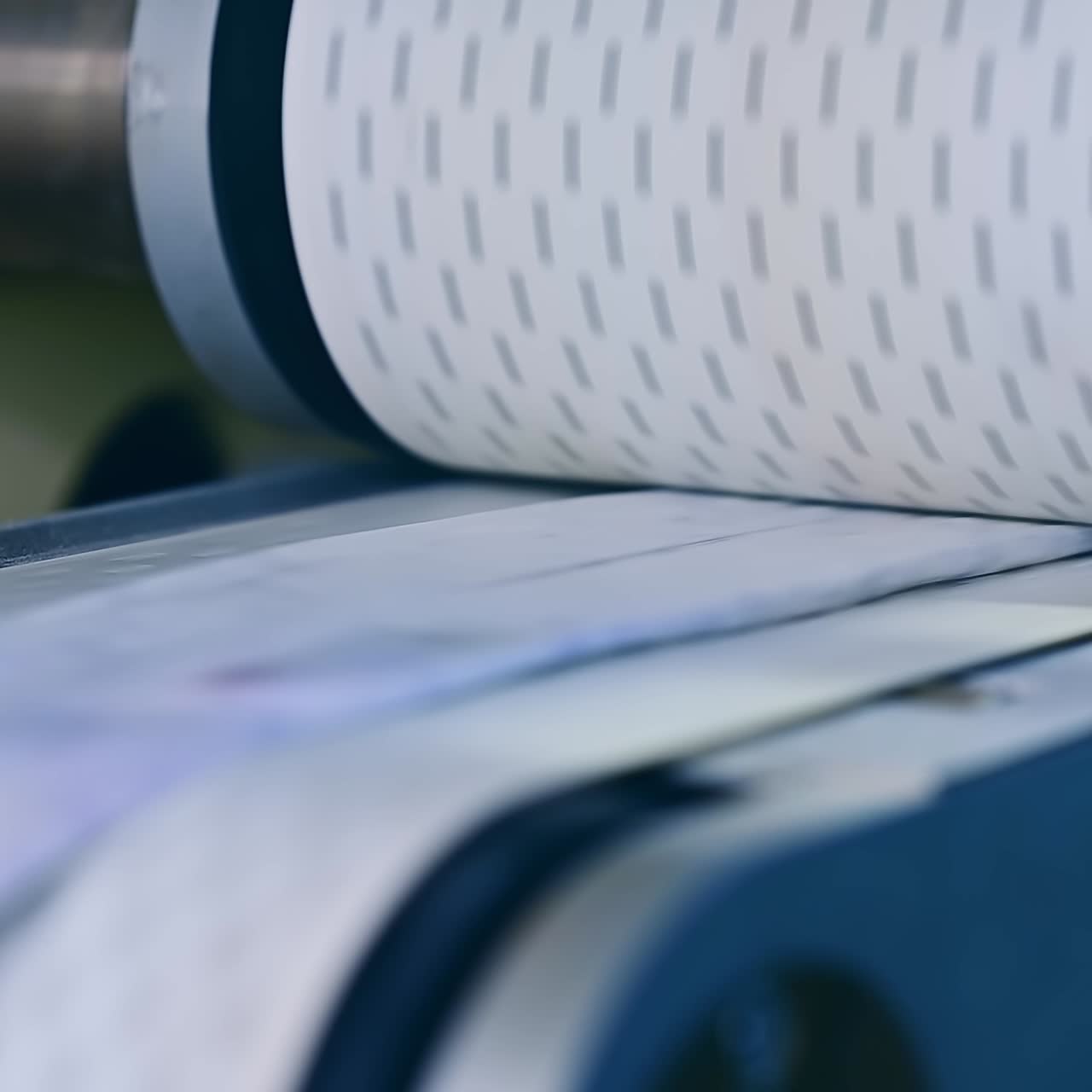 Conveyor at the factory for the production of diapers. Spinning shaft over the conveyor belt. Modern factory for producing diapers