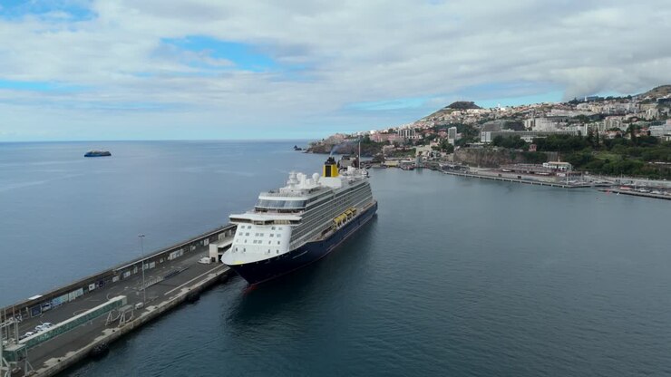 Spirit of Discovery cruise ship docked at port of Funchal, Madeira. Luxury vessel moored by promenade with coastal buildings in distance