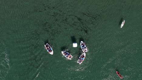 Vista-Aérea-De-Barcos-En-Aguas-Verdes-Y-Cristalinas,-Mostrando-Actividades-De-Ocio-Marino.