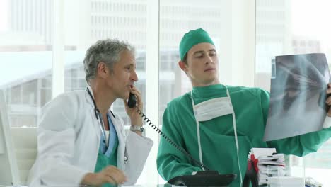 dos médicos varones mirando las radiografías