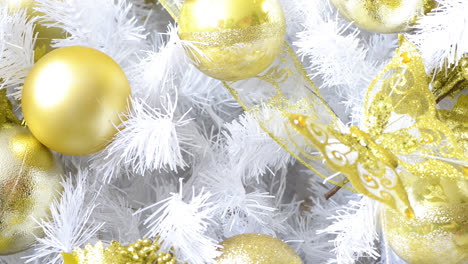 detalle de un hermoso árbol de navidad blanco adornado con objetos dorados