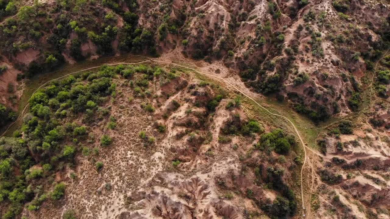 disparo de drones rodeando ciclistas de montaña en un cañón en un día soleado