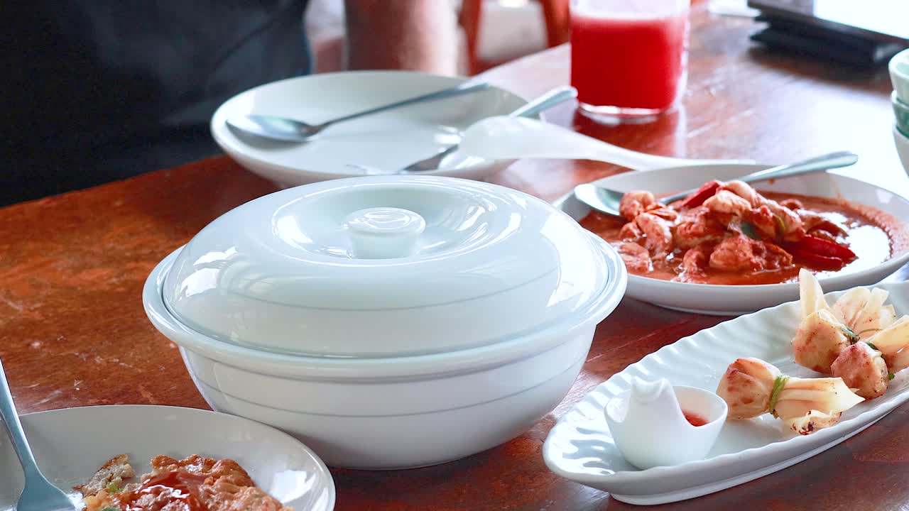 태국 푸켓의 한 테이블에서 활기찬 조명과 함께 준비되고 제공되는 태국 요리를 보여주는 시스