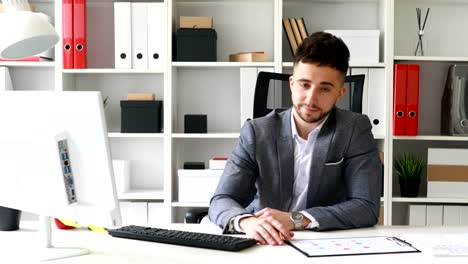 joven empresario en el lugar de trabajo mirando a la cámara
