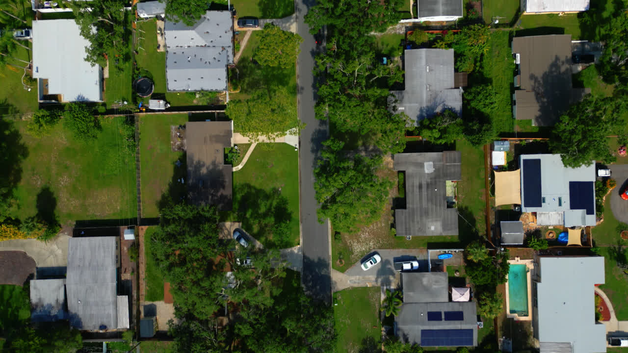Top down aerial view of Tampa suburban neighborhood with homes, lawns and trees in tight residential grid layout