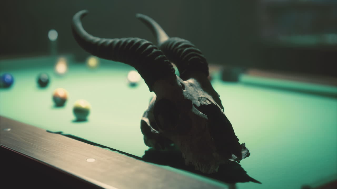 Skull with horns on a green billiard table with colorful balls scattered