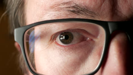 close up of a man putting on glasses