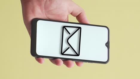 male hand shows phone with envelope sign on screen, vertical closeup