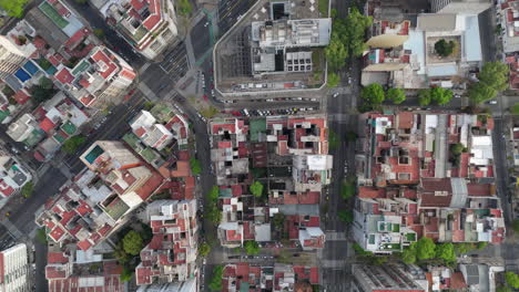 aerial overhead drone shot of a busy city with residential buildings, streets, and green spaces, showing the vibrant city life in buenos aires