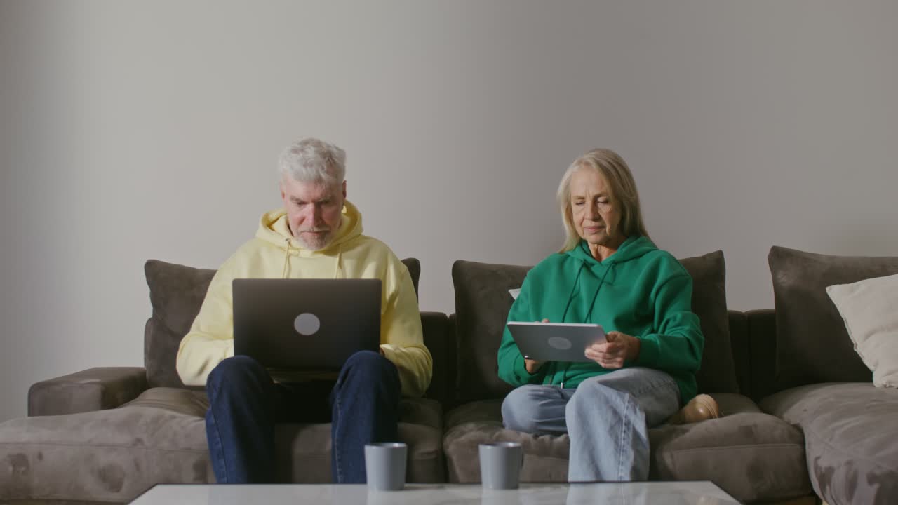 pareja de ancianos usando tecnología en el hogar