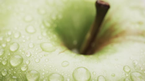 Micro-video-of-close-up-of-green-apple-with-water-drops-and-copy-space