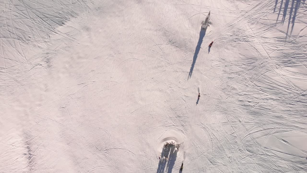 눈 위에서 트랙을 만드는 스노우모빌의 드론 오버헤드  ⁇