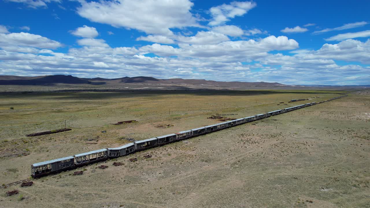 Drone side tracking shot over old train wagons and vintage telegraph poles