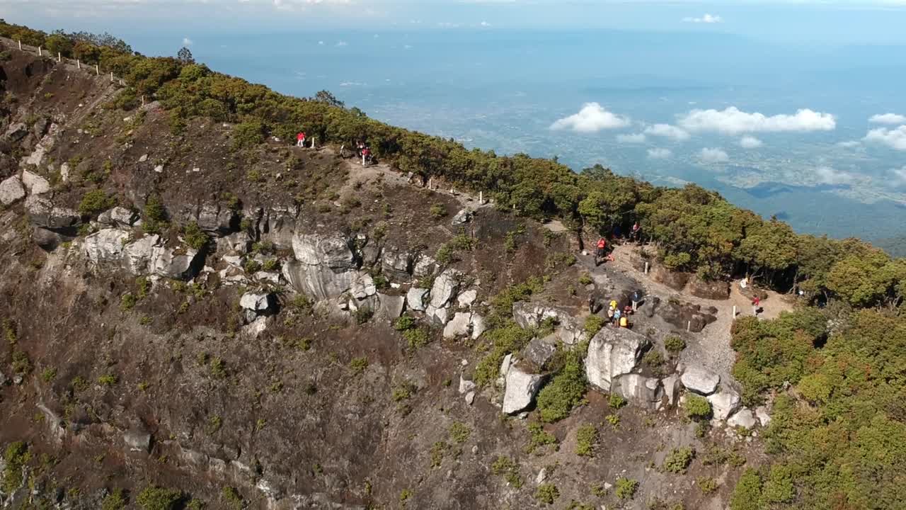 toma aérea de drones empujando en la cima de la montaña gede pangrango con gente caminando en la pista