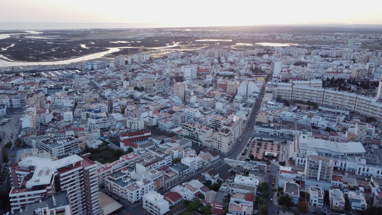 vista aérea del paisaje urbano de faro ria formosa en el fondo, puesta de sol, muñeca en
